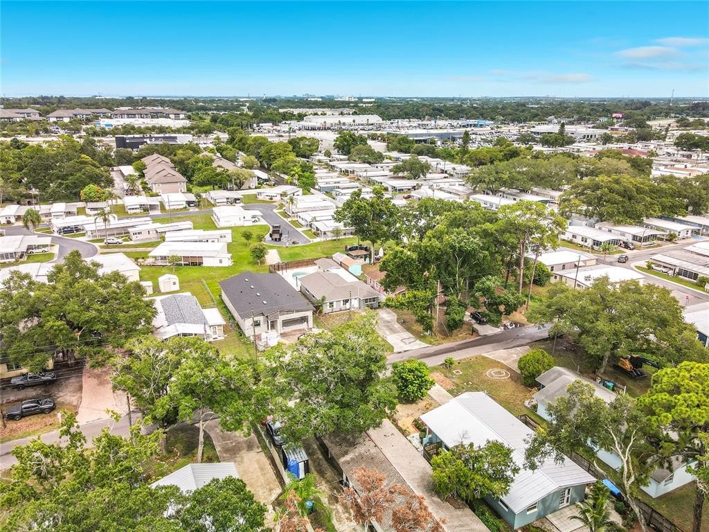 An aerial view shows a residential neighborhood with numerous single-story homes and mature trees — 381 69TH STREET N, CLEARWATER, FL