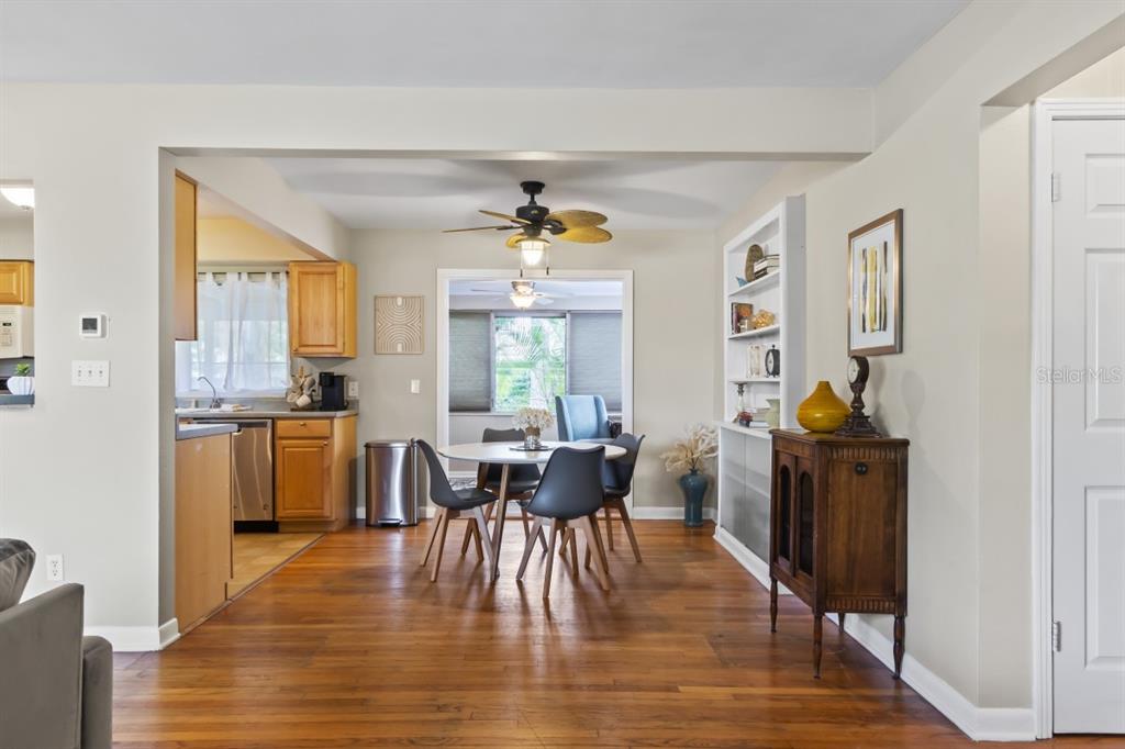 A dining area with a round table and chairs sits adjacent to a wood-cabinet kitchen — 1512 LIME STREET, CLEARWATER, FL