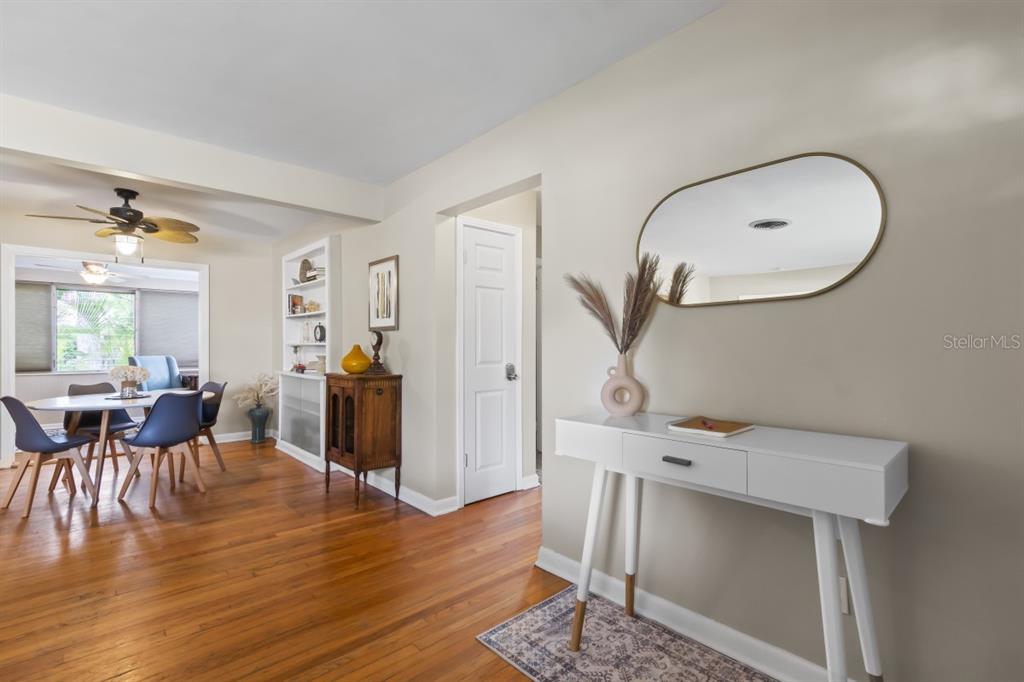 A dining area with hardwood floors and a white console table with a wall mirror — 1512 LIME STREET, CLEARWATER, FL