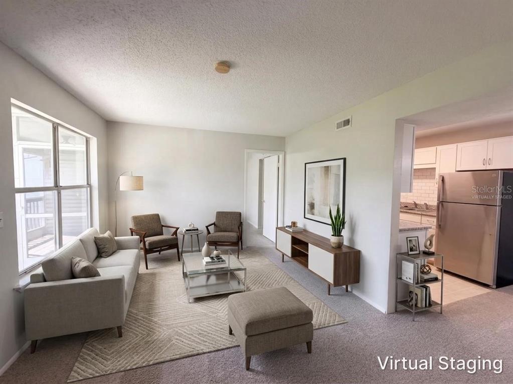 A living room with a sofa, two armchairs, a coffee table, and an adjacent kitchen — 1600 BIG TREE ROAD UNIT A6, DAYTONA BEACH, FL
