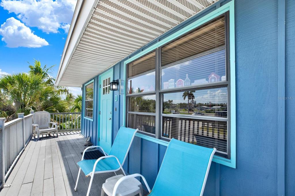 A blue exterior wall features a door labeled D and a large window with blinds — 315 58TH STREET UNIT D, HOLMES BEACH, FL