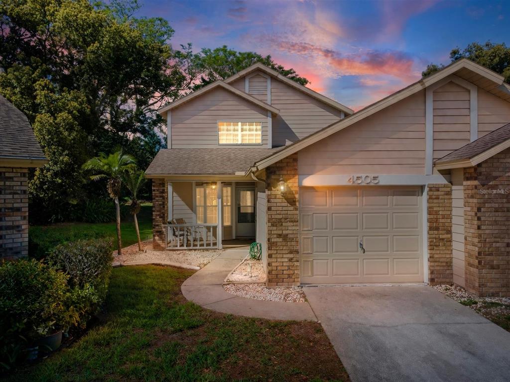 A two-story house with tan siding, a brick facade, and a single-car garage — 4505 GLEN HOLLOW, NEW PORT RICHEY, FL