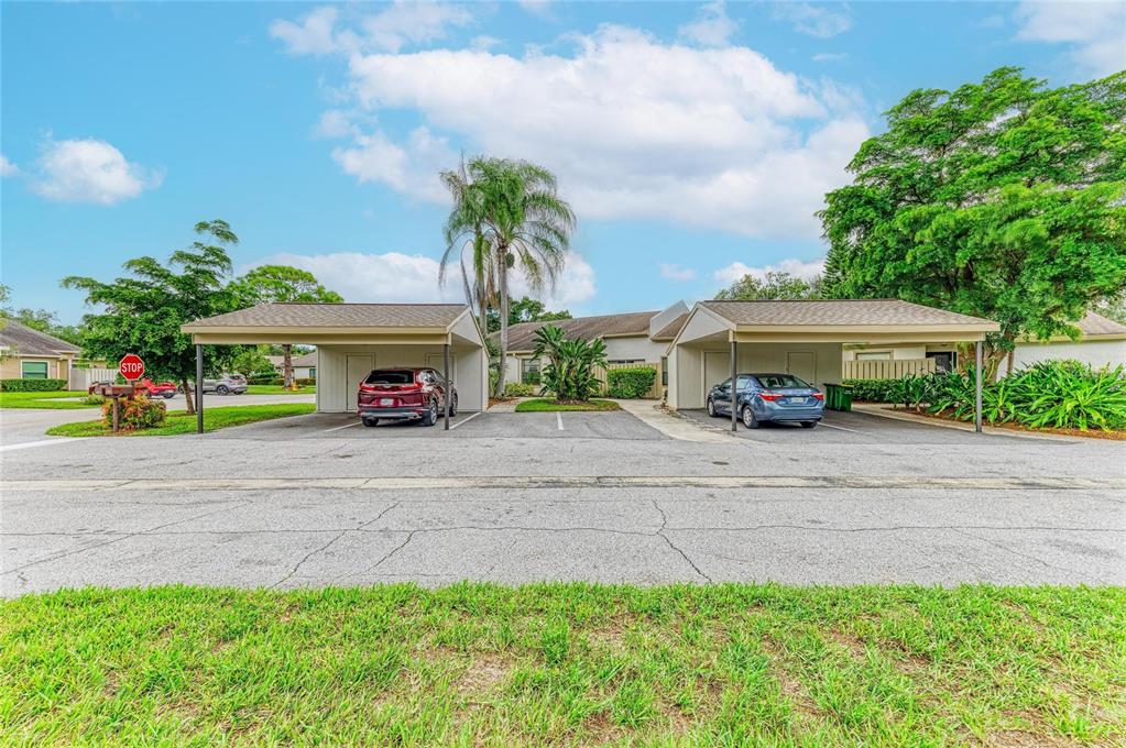 A single-story house exterior features a stone-accented entryway, a dark front door, and landscaping — 3405 TALLYWOOD LANE UNIT 7130, SARASOTA, FL