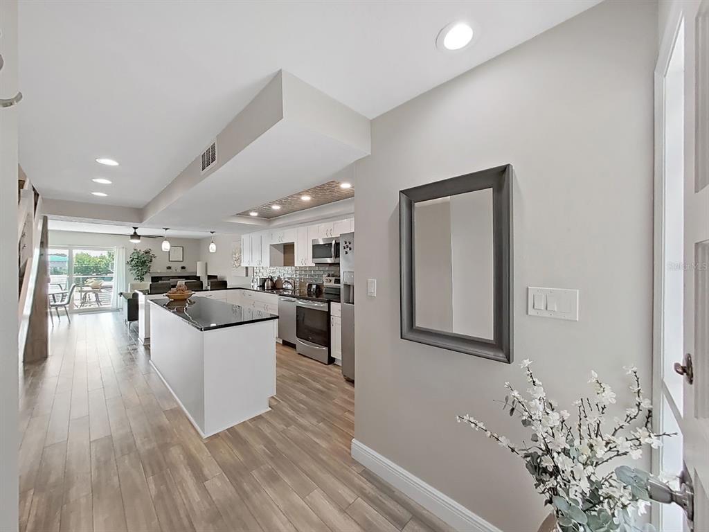 A view from an entryway looking into a kitchen with a white island and flooring — 433 S PAULA DRIVE UNIT 18, DUNEDIN, FL