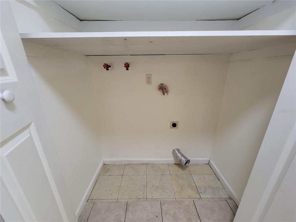 A laundry closet features a white shelf, water hookups, an electrical outlet, and dryer venting — 14297 SW 39TH TERRACE, OCALA, FL