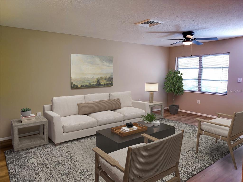 This living room features a white sofa, two armchairs, a coffee table, and a large rug — 6064 ARLENE WAY UNIT 6064, BRADENTON, FL