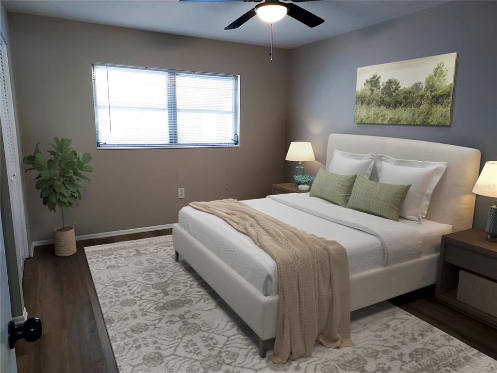 A bedroom features a white upholstered bed, a patterned area rug, and a ceiling fan — 6064 ARLENE WAY UNIT 6064, BRADENTON, FL