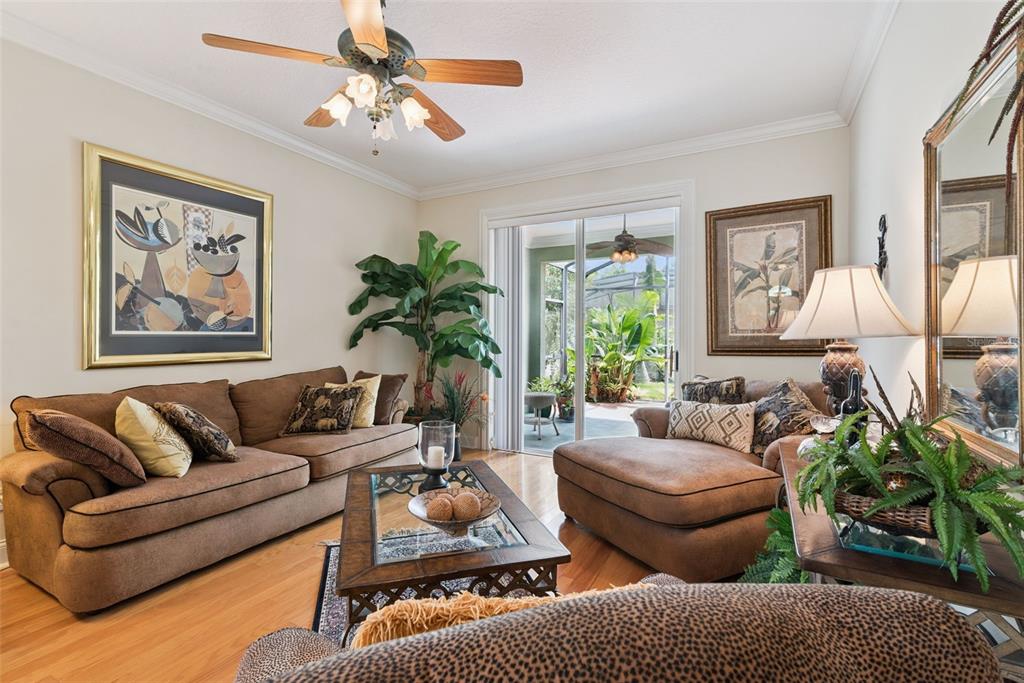 A living room features brown sofas, a glass-top coffee table, and sliding doors to a patio — 107 PEREGRINE COURT, WINTER SPRINGS, FL