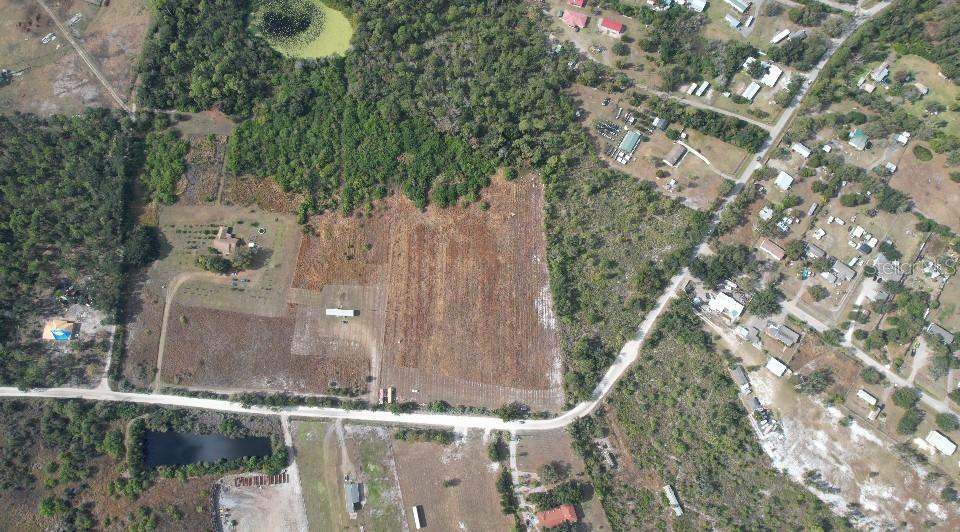 An aerial view shows a large, cleared plot of land with a house and outbuilding — 14421 SEMINOLE TRAIL, WIMAUMA, FL