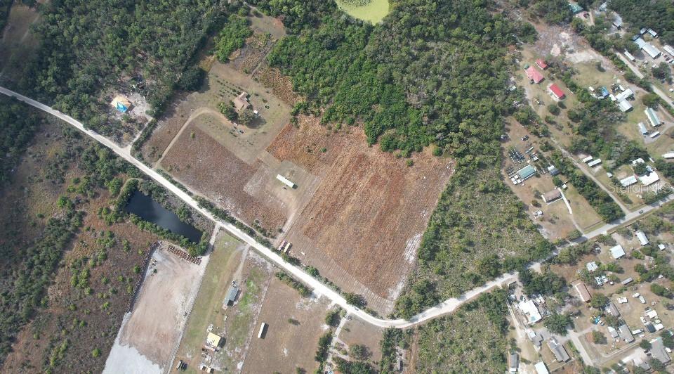 An aerial view shows a large, cleared lot with a house, outbuildings, and surrounding woods — 14421 SEMINOLE TRAIL, WIMAUMA, FL