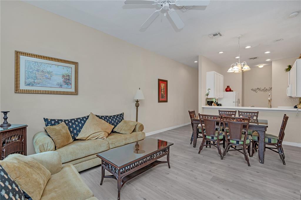 A living room with a sofa and coffee table sits adjacent to a dining area — 514 LUCAYA LOOP UNIT 514, DAVENPORT, FL