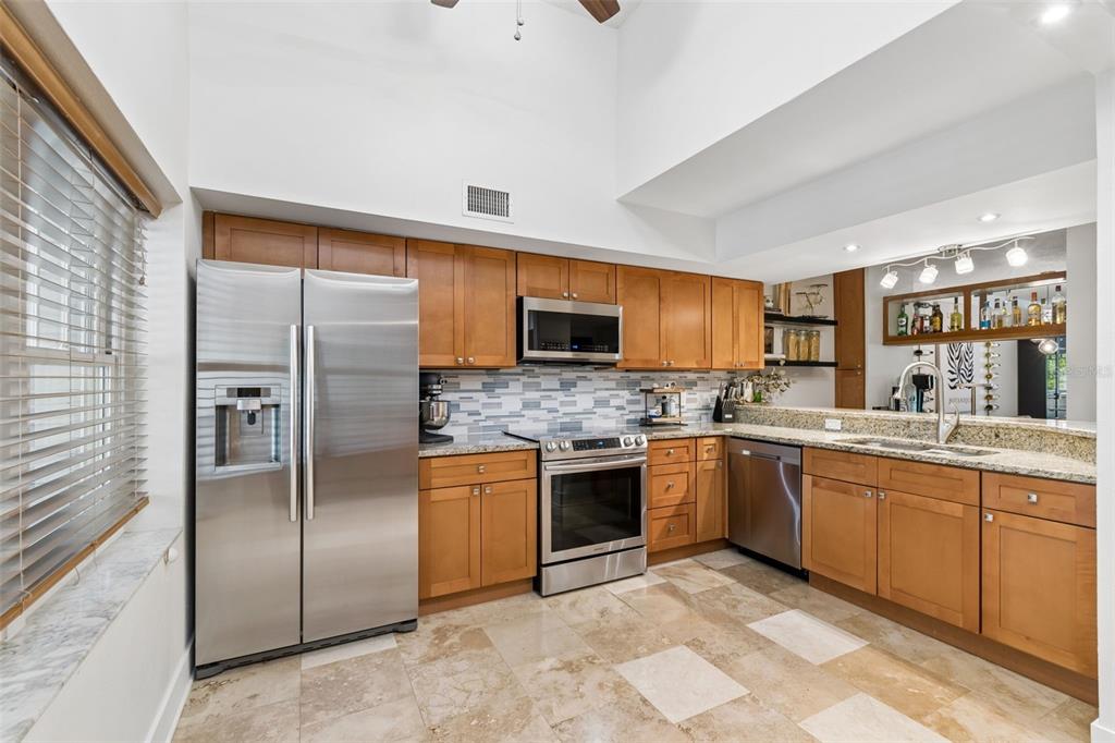 A built-in wooden coffee bar features cabinetry, a countertop, and artwork in a home interior — 2599 DOLLY BAY DRIVE UNIT 302, PALM HARBOR, FL