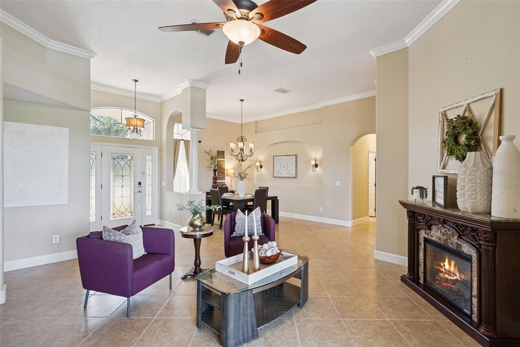 A dining room with a dark table, chandelier, and tile flooring near an arched entryway — 3149 CURVING OAKS WAY, ORLANDO, FL