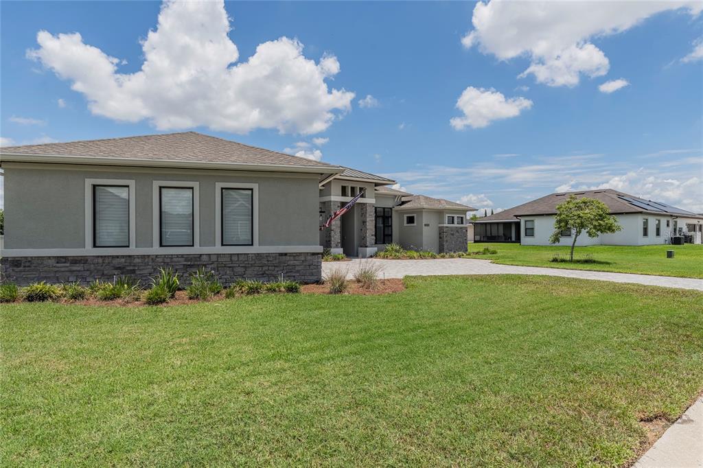 An aerial view shows a single-story house with a paved driveway and a large backyard — 6545 EMERALD WOODS LANE, LAKELAND, FL
