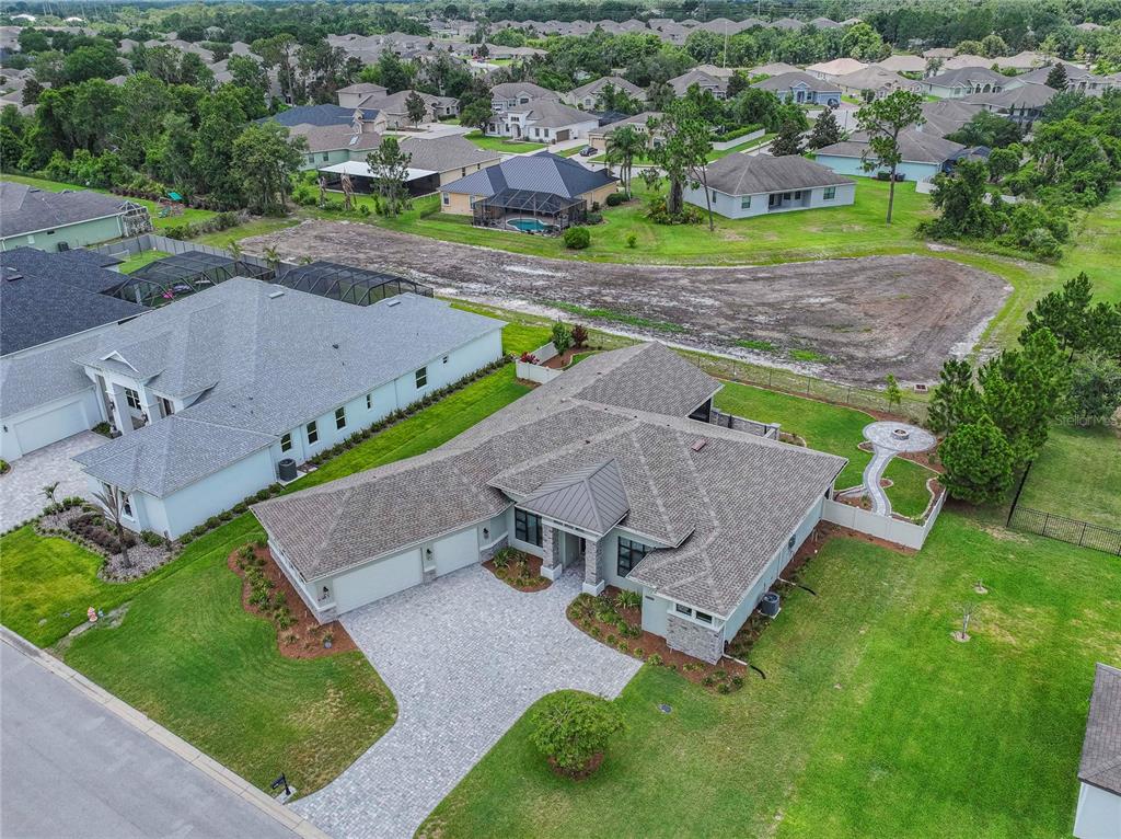 A kitchen island with granite countertops sits in front of white cabinets and a wet bar — 6545 EMERALD WOODS LANE, LAKELAND, FL