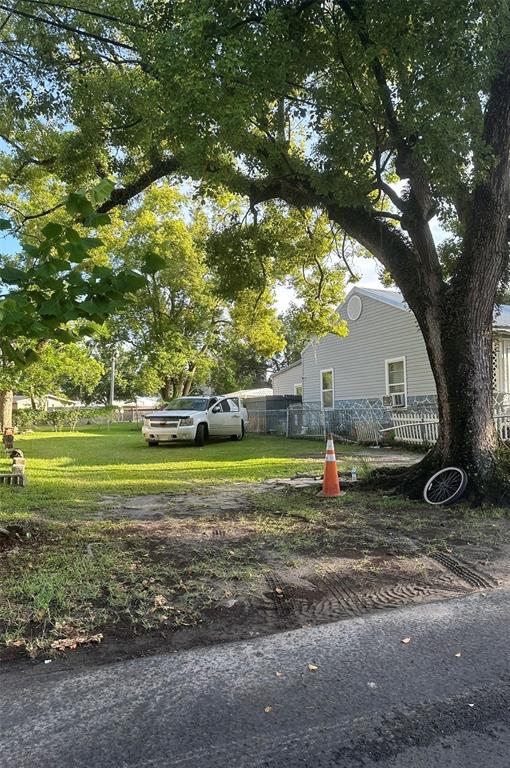 A white SUV is parked on the grassy lawn in front of a gray house — HARDEE STREET, JACKSONVILLE, FL