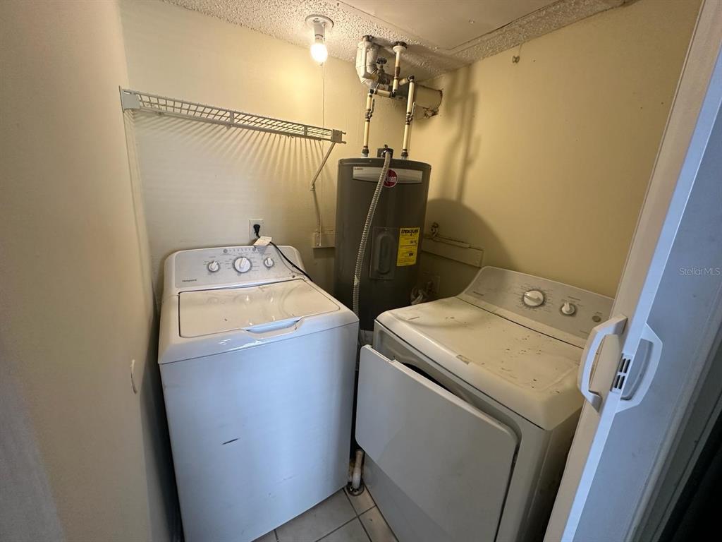 A laundry closet contains a washing machine, a clothes dryer, and a water heater — 1972 LAKE ATRIUMS CIRCLE UNIT 199, ORLANDO, FL