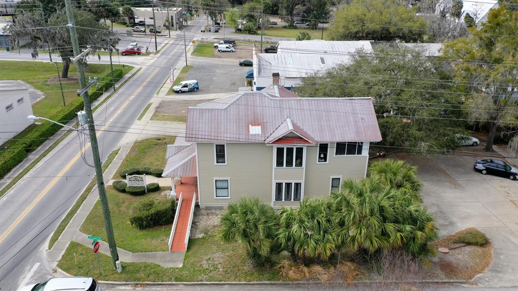 An aerial view shows a two-story house with a metal roof and a wheelchair ramp — 151 SE 8TH STREET, OCALA, FL