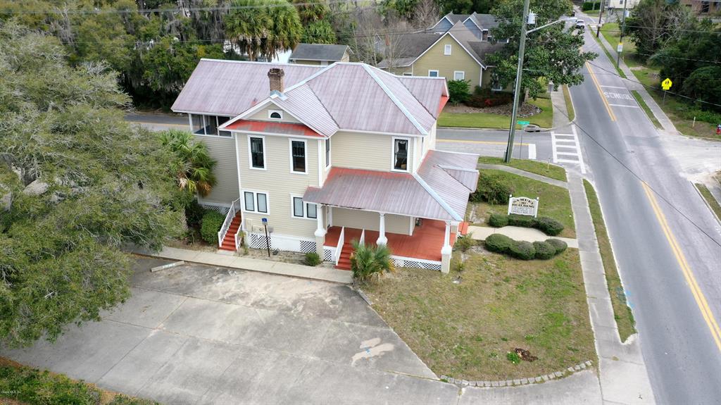 An aerial view of a two-story tan house with a metal roof and front porch — 151 SE 8TH STREET, OCALA, FL