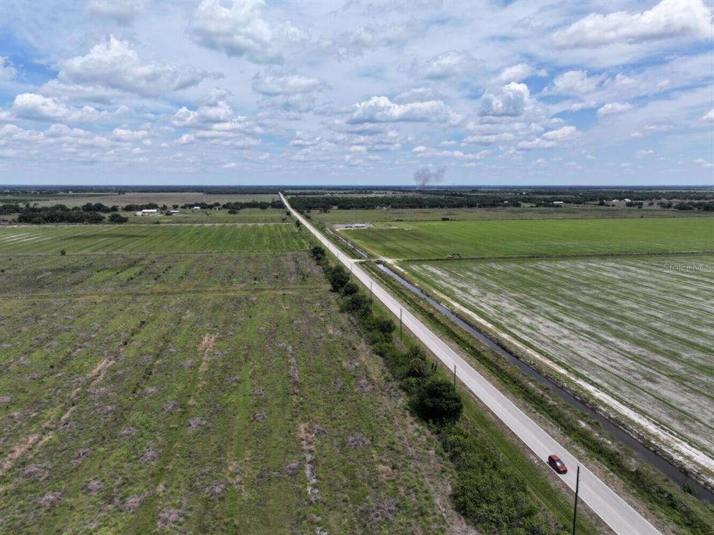 An aerial view shows a paved road running through flat, open rural land — 6691 SE COUNTY ROAD 763, ARCADIA, FL