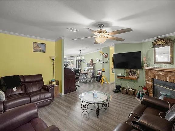 A living room features a brown leather sofa, a glass coffee table, and a fireplace — 15340 NW 65TH AVENUE ROAD, REDDICK, FL