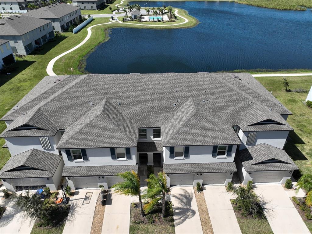 An aerial view shows a multi-unit townhouse building with gray roofs and attached garages — 928 ROYAL EMPRESS DRIVE, RUSKIN, FL