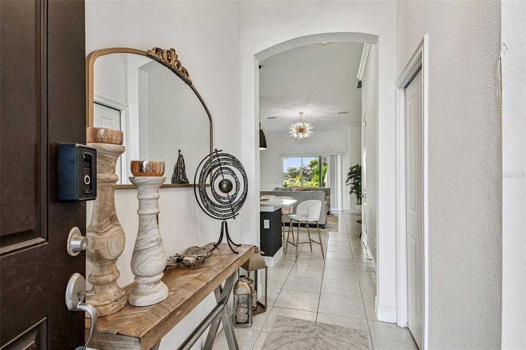 An entryway features a wooden console table, decorative accents, and a view into an open living area — 1039 DAVIS HEATHER CIRCLE, SEFFNER, FL