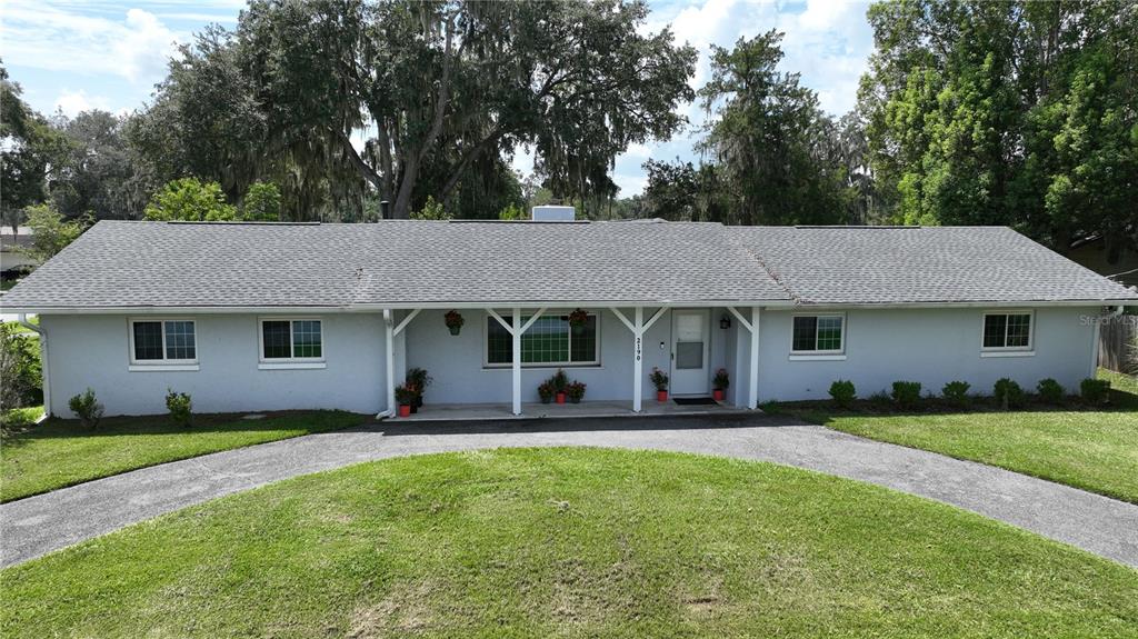 A single-story house with a light-colored exterior and a long driveway sits on a lawn — 2190 SE 39TH STREET, OCALA, FL