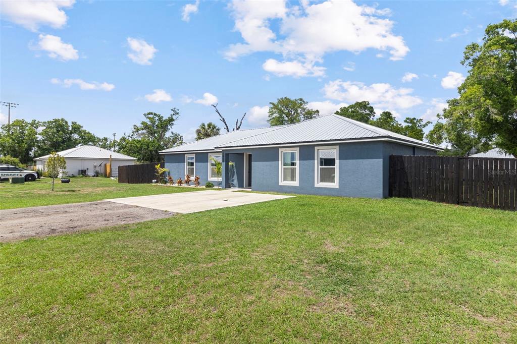 A blue single-story house with a metal roof and a concrete driveway in a yard — 1620 SE HAVEN DRIVE, ARCADIA, FL