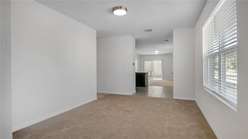 A bright living room features a beige sofa, round coffee table, and an armchair — 3503 DIAMOND LEAF COURT, VALRICO, FL