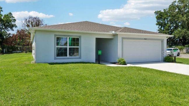 A single-story house with a white exterior, a two-car garage, and a large front lawn — TBD MIRAGE AVENUE, WEEKI WACHEE, FL