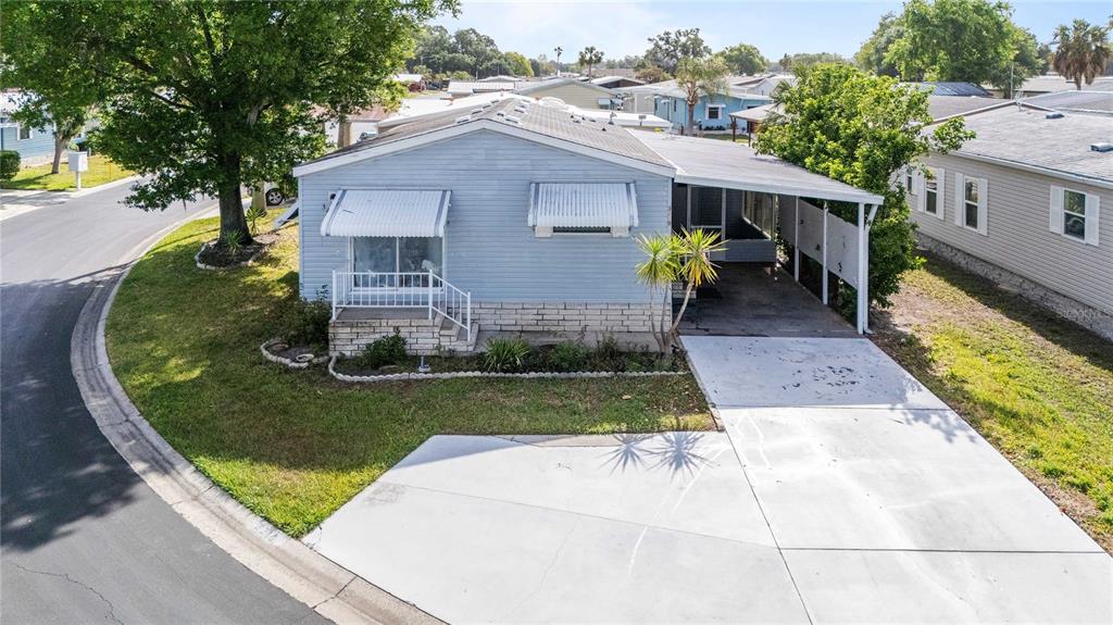 A light blue manufactured home with a small front porch and a paved driveway — 3210 HICKORY DRIVE, WESLEY CHAPEL, FL