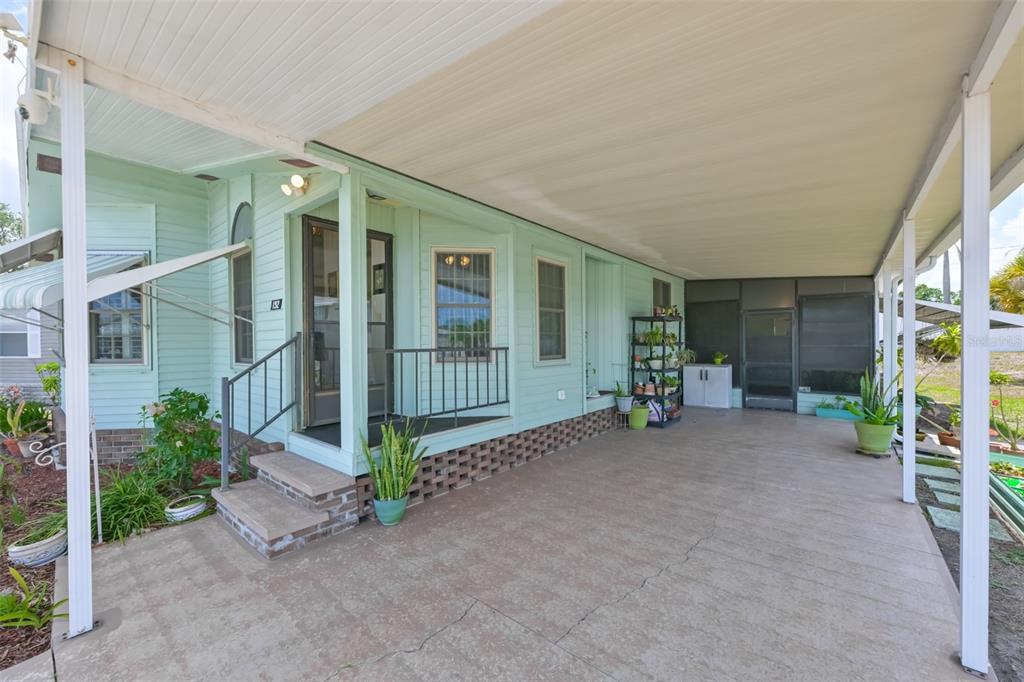 A light green mobile home features a covered concrete carport and a small front porch — 192 S PORT ROYAL LANE, APOLLO BEACH, FL
