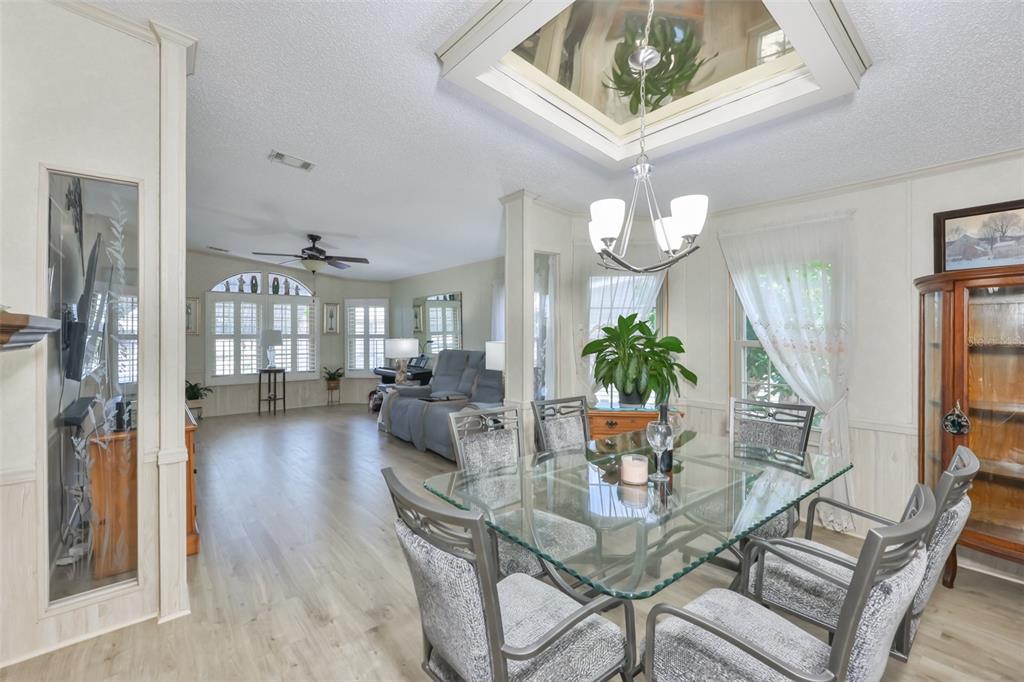 A dining area with a glass table and chairs sits adjacent to a living room — 192 S PORT ROYAL LANE, APOLLO BEACH, FL