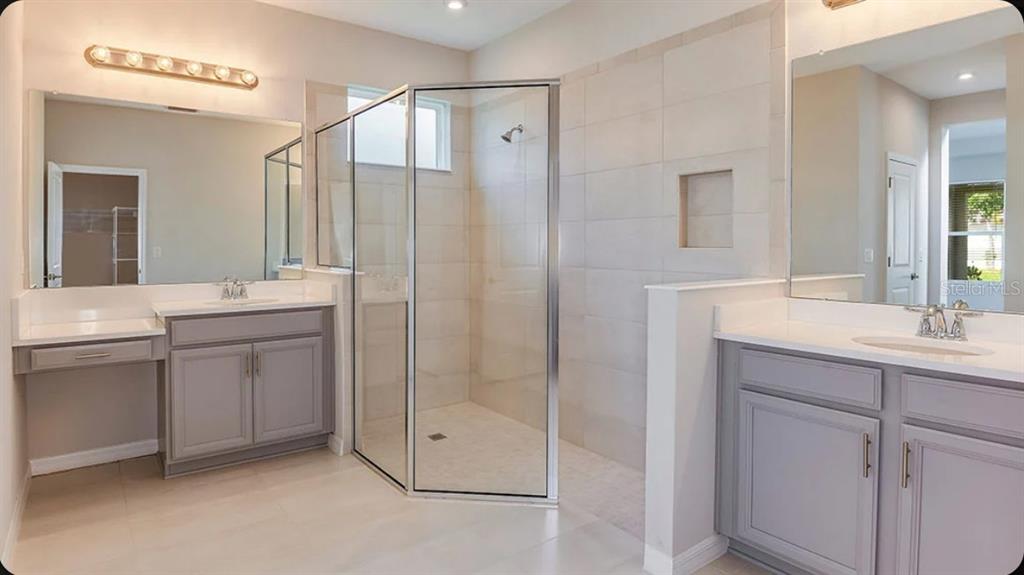 A modern kitchen features light gray cabinets, white countertops, stainless steel appliances, and wood flooring — 5769 BINNACLE LANE, COCOA, FL