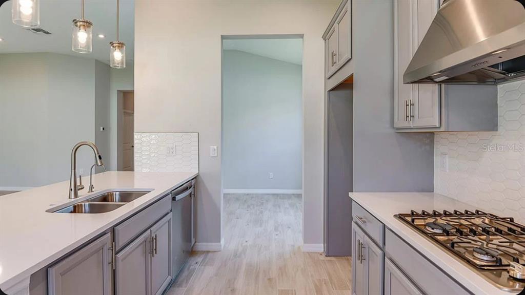 An empty room with light gray walls, wood-look tile flooring, and a large window — 5769 BINNACLE LANE, COCOA, FL