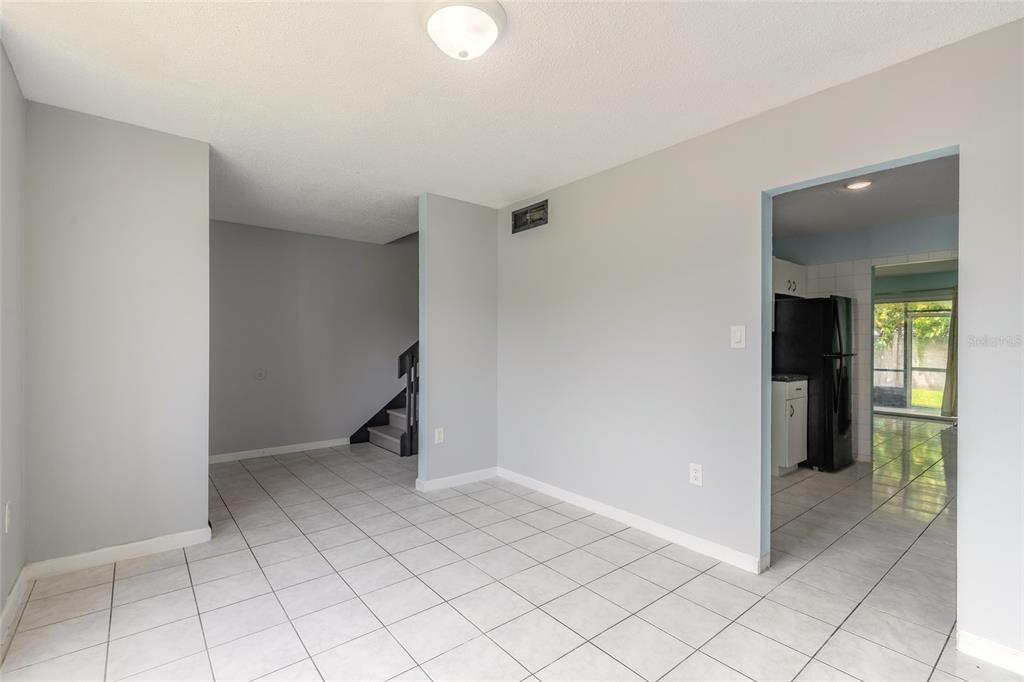 A bright room with light blue walls, white tile flooring, and a large window — 5060 DOWNING STREET UNIT 6, ORLANDO, FL