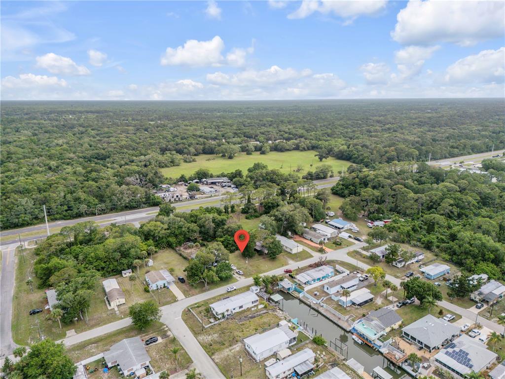An aerial view shows a residential neighborhood with a red location pin on a lot — NELLIE STREET, EDGEWATER, FL
