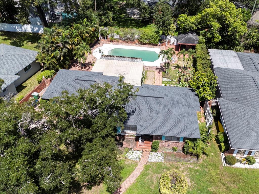 An aerial view shows a house with a dark shingled roof, pool, and surrounding trees — 451 W DAVIS BOULEVARD, TAMPA, FL