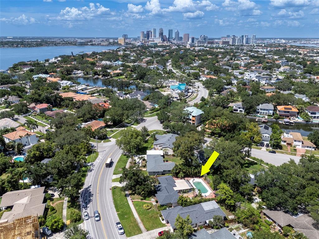 An aerial view shows a residential neighborhood with a pool highlighted by a yellow arrow — 451 W DAVIS BOULEVARD, TAMPA, FL