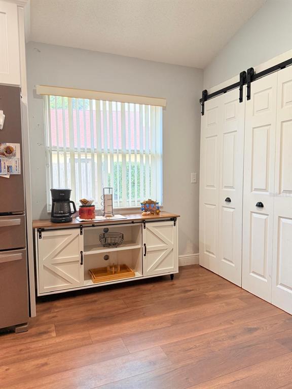 A kitchen area features a coffee station on a white barn-door console near sliding doors — 16425 GOLDEN EAGLE BOULEVARD, CLERMONT, FL