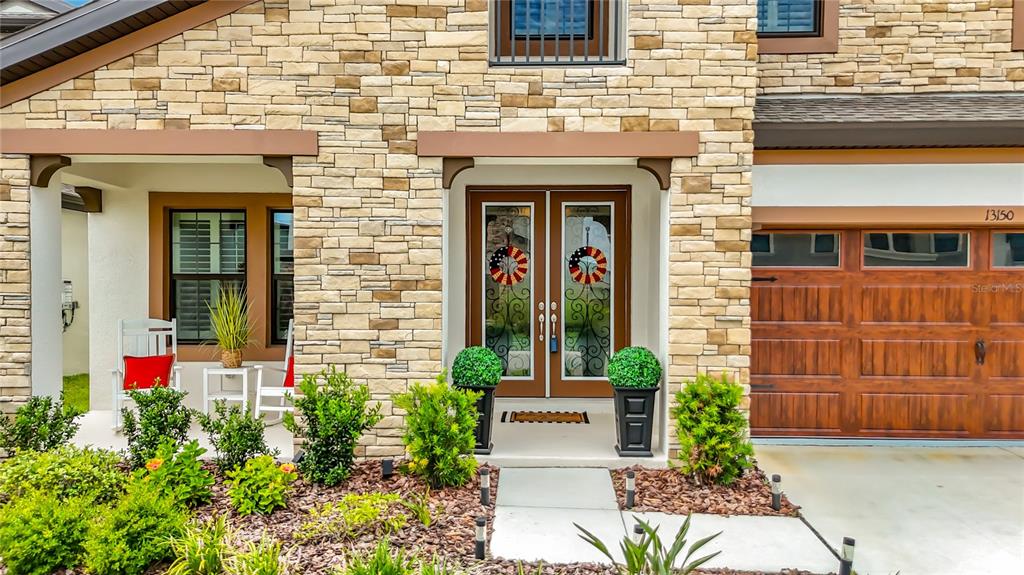 A pair of brown double front doors with glass inserts and star-shaped wreaths — 13150 WELLSPRING DRIVE, LITHIA, FL