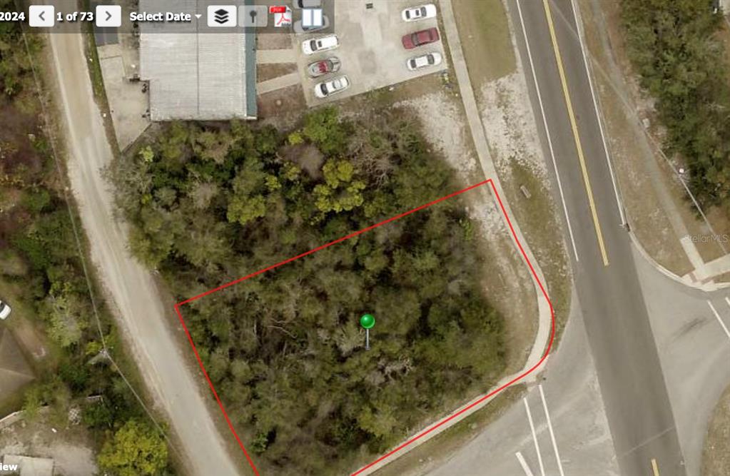 An aerial view shows a vacant, tree-covered lot outlined in red next to a road — 1850 PROVIDENCE BOULEVARD, DELTONA, FL