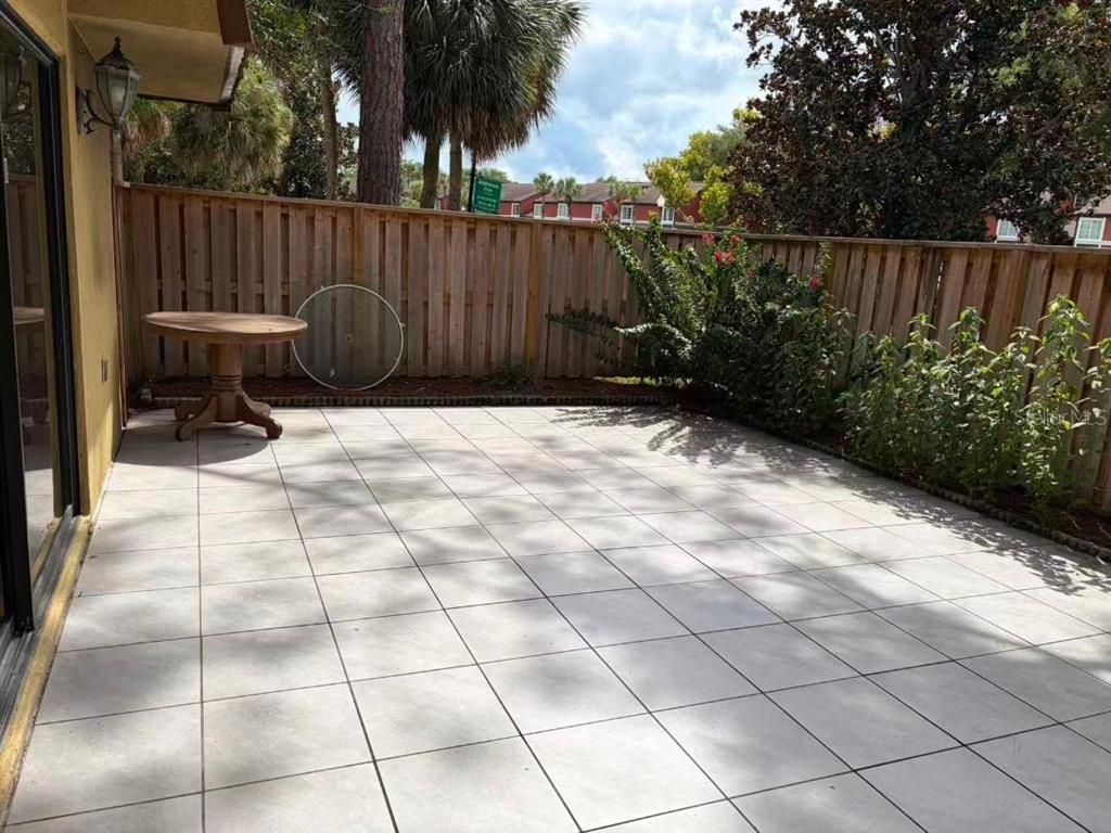 A low-angle exterior view of a multi-unit residential building surrounded by trees and grass — 5371 BAMBOO COURT UNIT 401, ORLANDO, FL