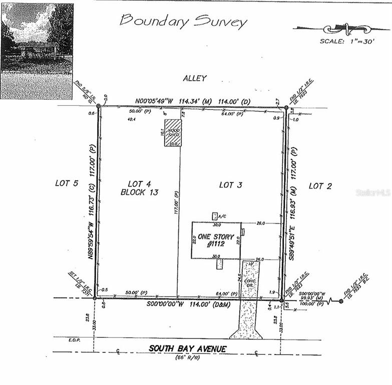 A side view of a house with concrete block walls and a large grassy yard — 1112/1114 S BAY AVENUE, SANFORD, FL