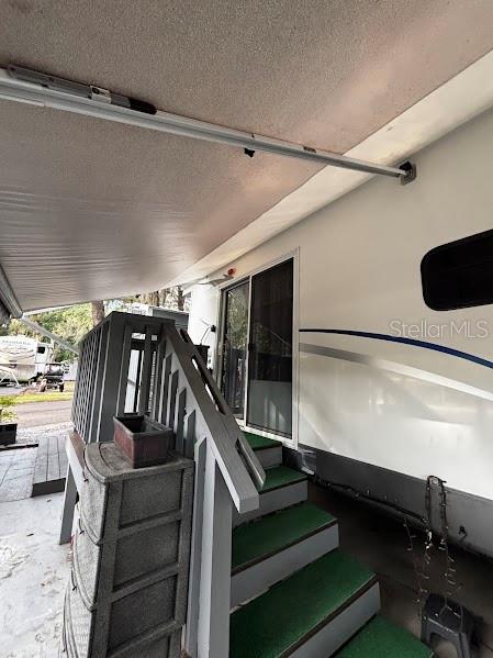 An exterior view of a recreational vehicle with a gray staircase and an extended awning — 25367 140TH STREET NE UNIT 315, FORT MC COY, FL