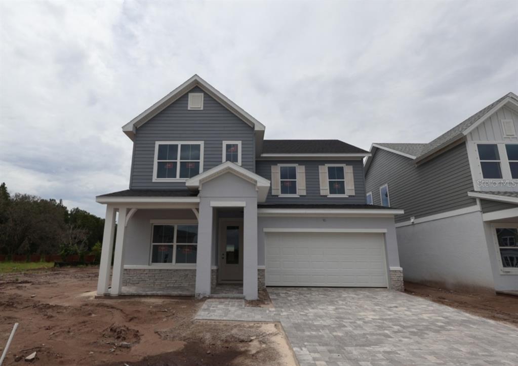 A two-story house with gray siding, a stone base, and a paved driveway — 2794 SOLETA VIEW, ODESSA, FL