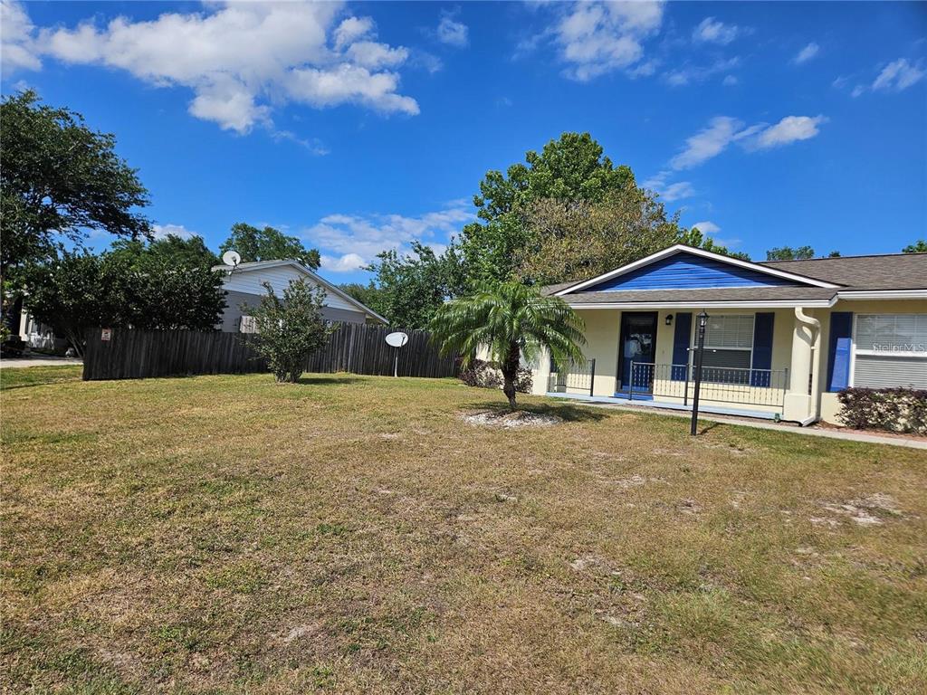 A one-story house with a blue-trimmed roof and a large, grassy front yard — 375 WILLOW SONG COURT, EUSTIS, FL