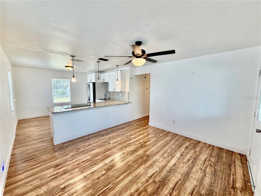 A single-story house with light gray siding, a screened-in porch, and a shingled roof — 311 W BELLA VISTA STREET, LAKELAND, FL