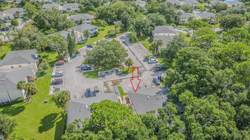 An aerial view shows a multi-unit residential building with a gray roof and parking lot — 133 SABAL COURT UNIT F, OLDSMAR, FL